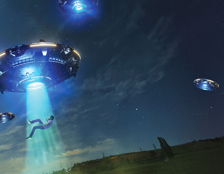 Three flying saucers. One is abducting a boy.