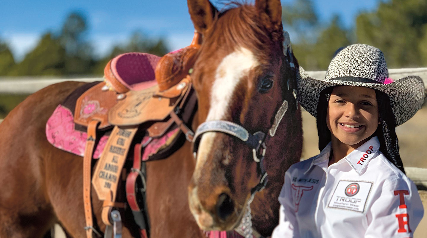 Savannah Roberts smiles next to her horse.