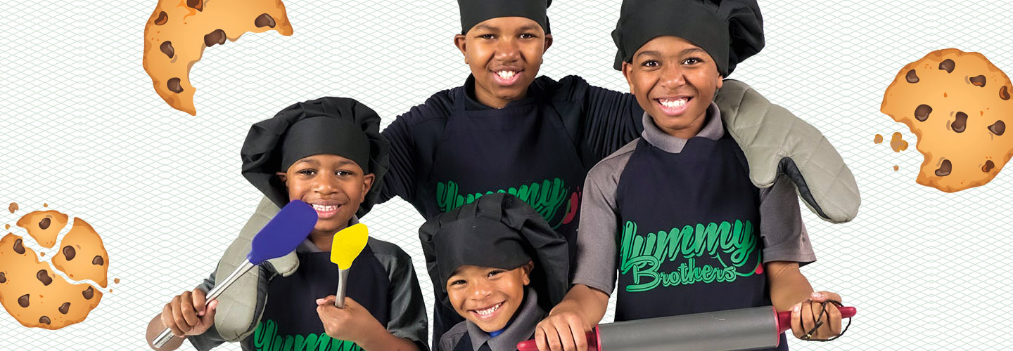 The 4 Billingslea brothers wear chef’s hats and smile while holding baking tools.