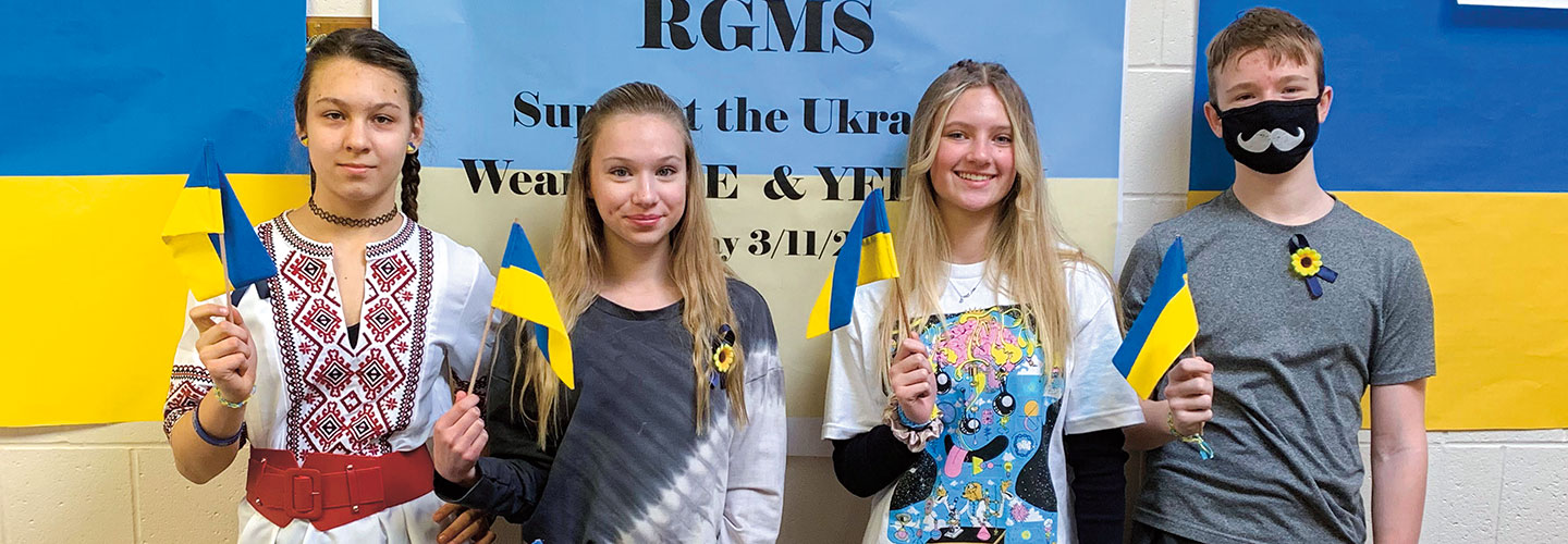Four kids wave Ukrainian flags