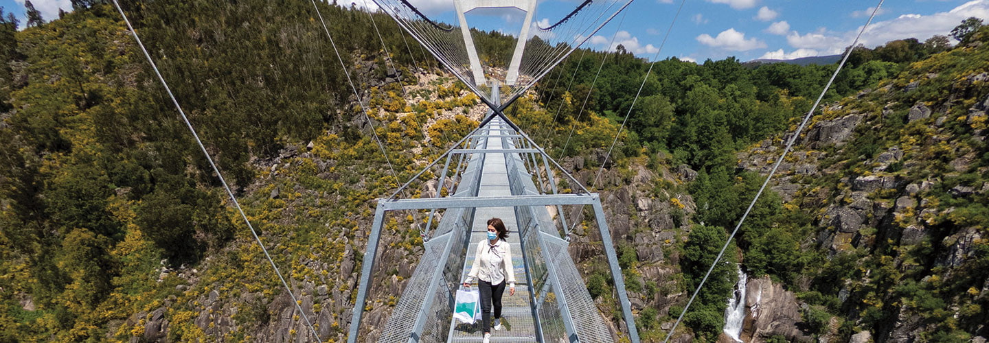 A woman walking on a high thin metal bridge