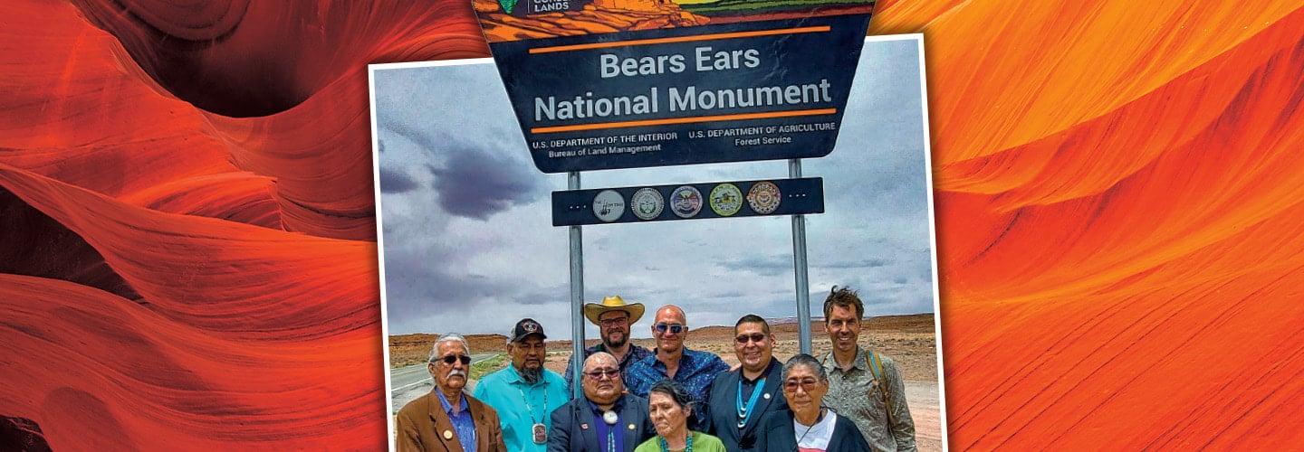 Photo of people posing in front of a sign for the "Bears Ears National Monument"
