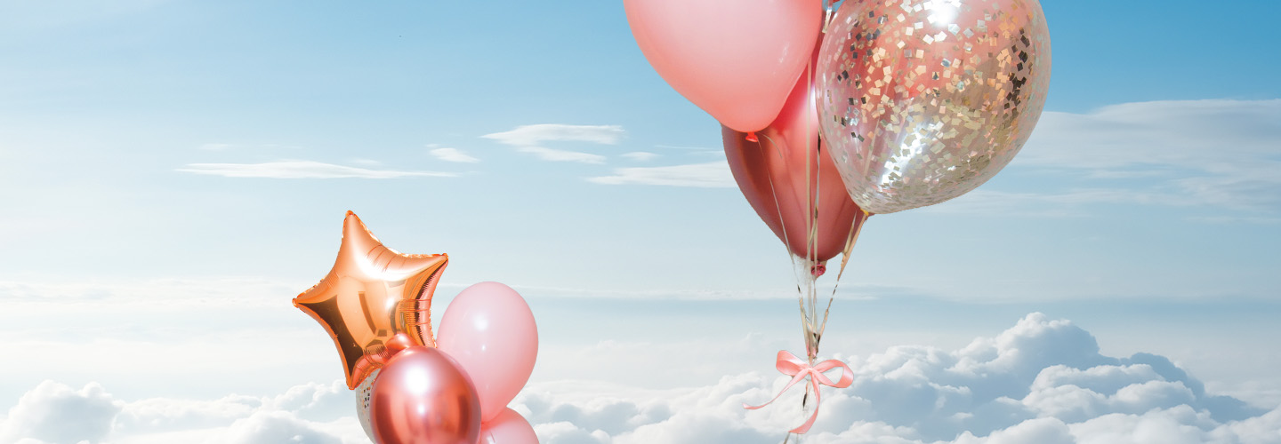 Image of pink balloons floating high into the sky