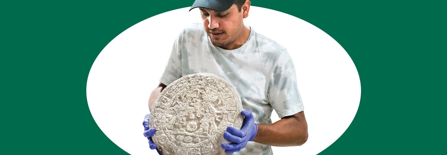 Image of a scientist holding an ancient circular artifact