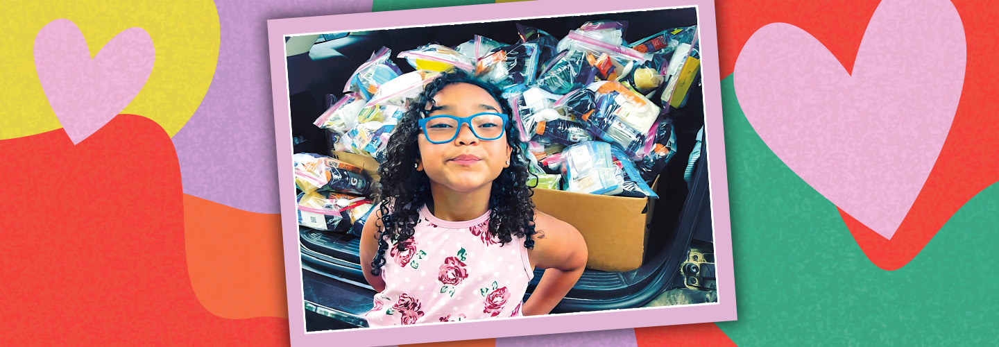 Photo of a kid posing in front of a large box of collected donated food against background of hearts