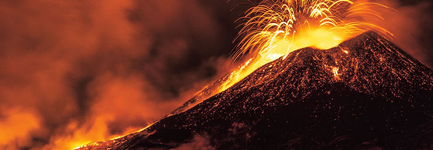 Volcano erupting with bright orange lava and sparks shooting from the crater